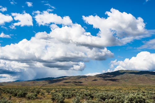 Hilly terrain against picturesque cloudy blue sky