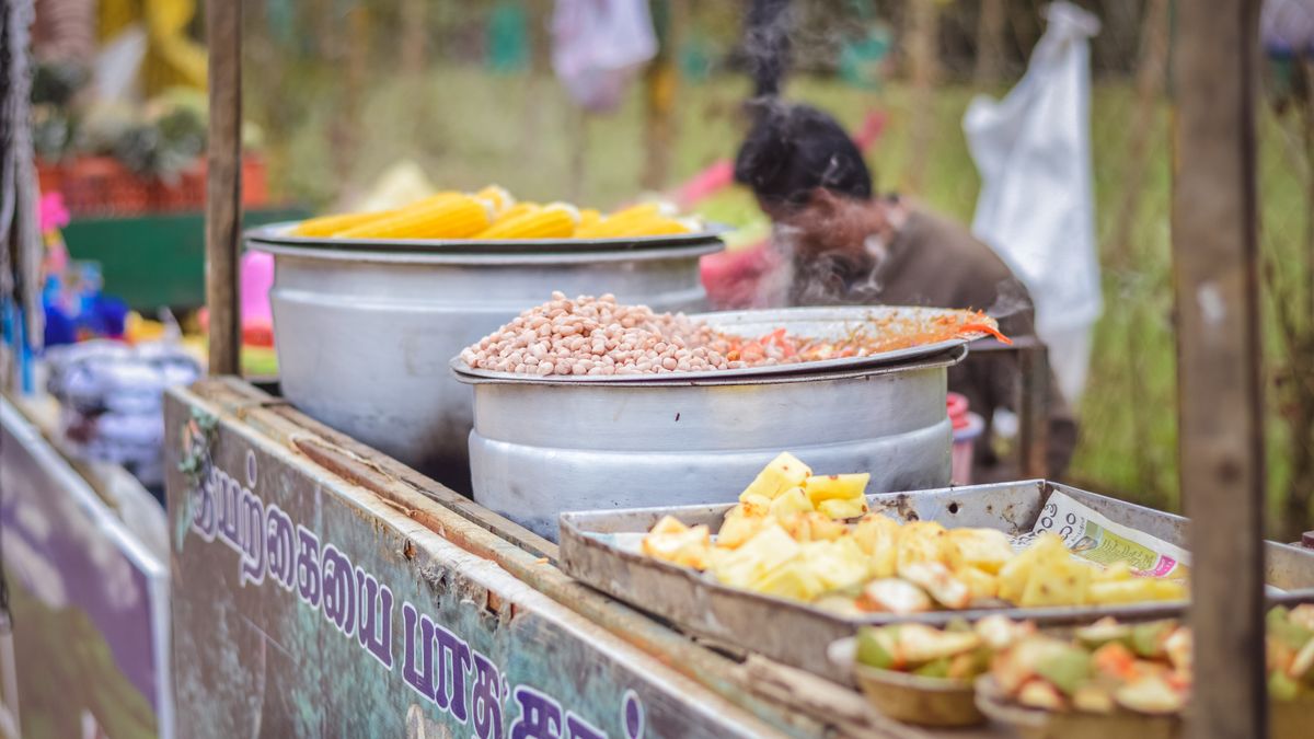 Vibrant street food stall in India showcasing steaming hot dishes, perfect for travel photography.