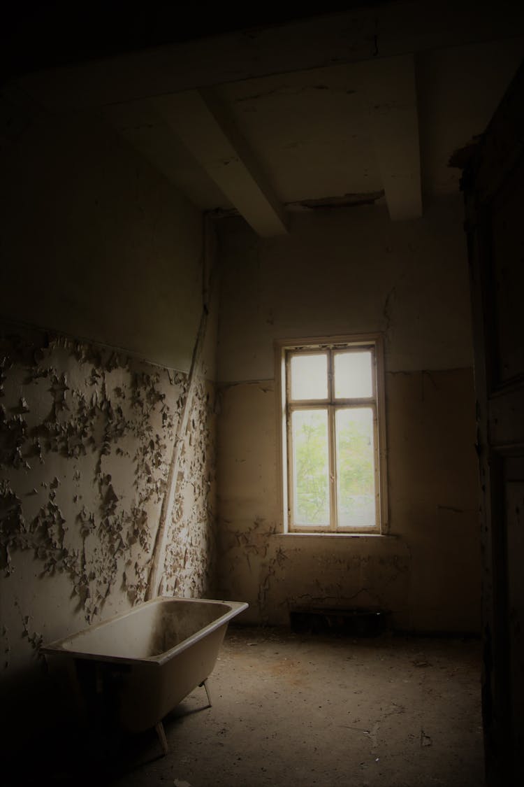 Interior Of Damaged Old Bathroom With Weathered Walls