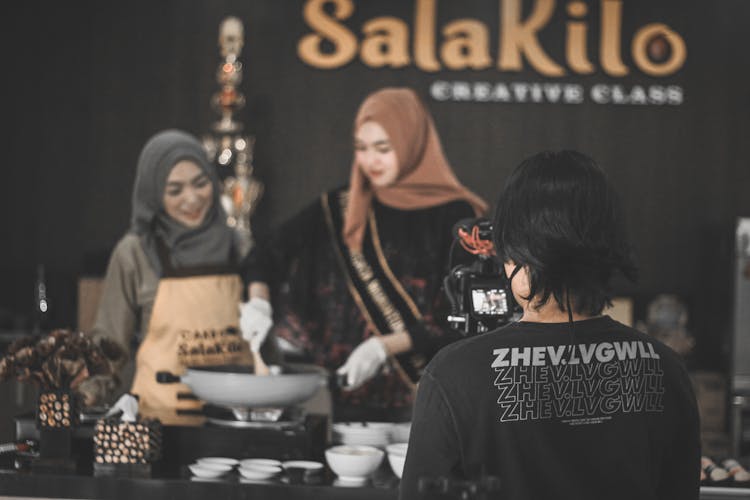 Positive Ethnic Female Cooks Preparing Dinner During Photo Session