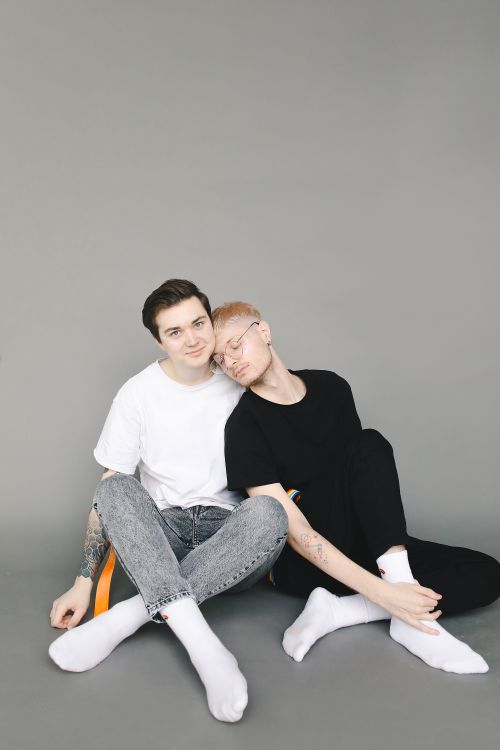 Free A young couple sitting together, symbolizing love and togetherness in a minimalist studio. Stock Photo