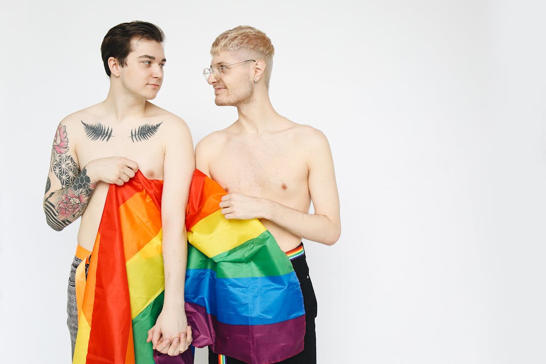 Free Men With a Gay Pride Flag Holding Hands Stock Photo