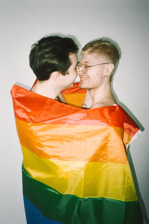 Free Men Wrapped in Gay Pride Flag Stock Photo