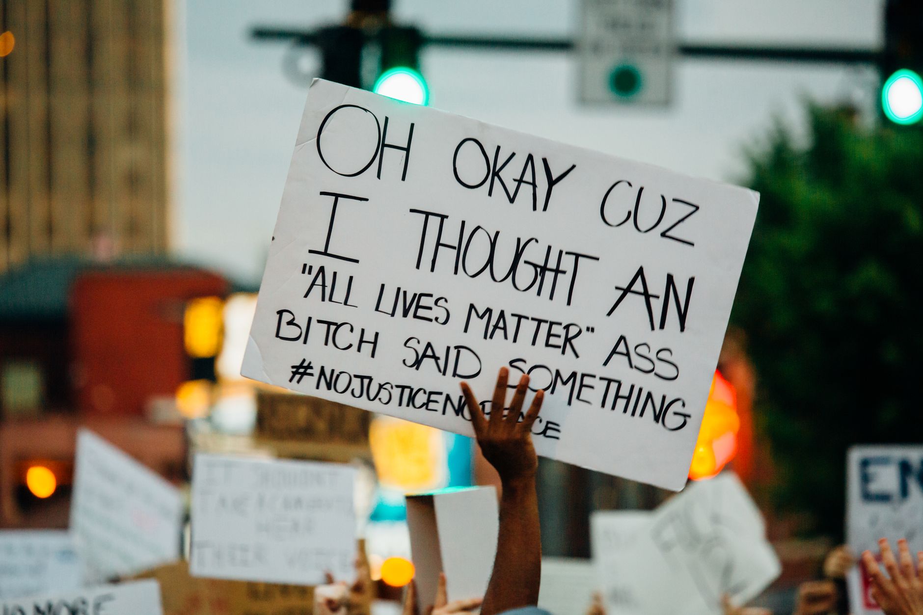 Crop unrecognizable African American person with banner protesting for human rights and against racism on street