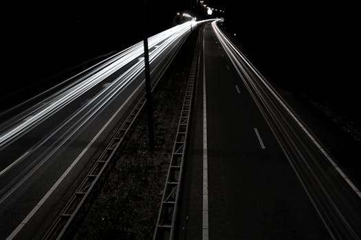 这张迷人的长曝光照片捕捉了夜间高速公路灯光的运动轨迹，呈现出动态效果