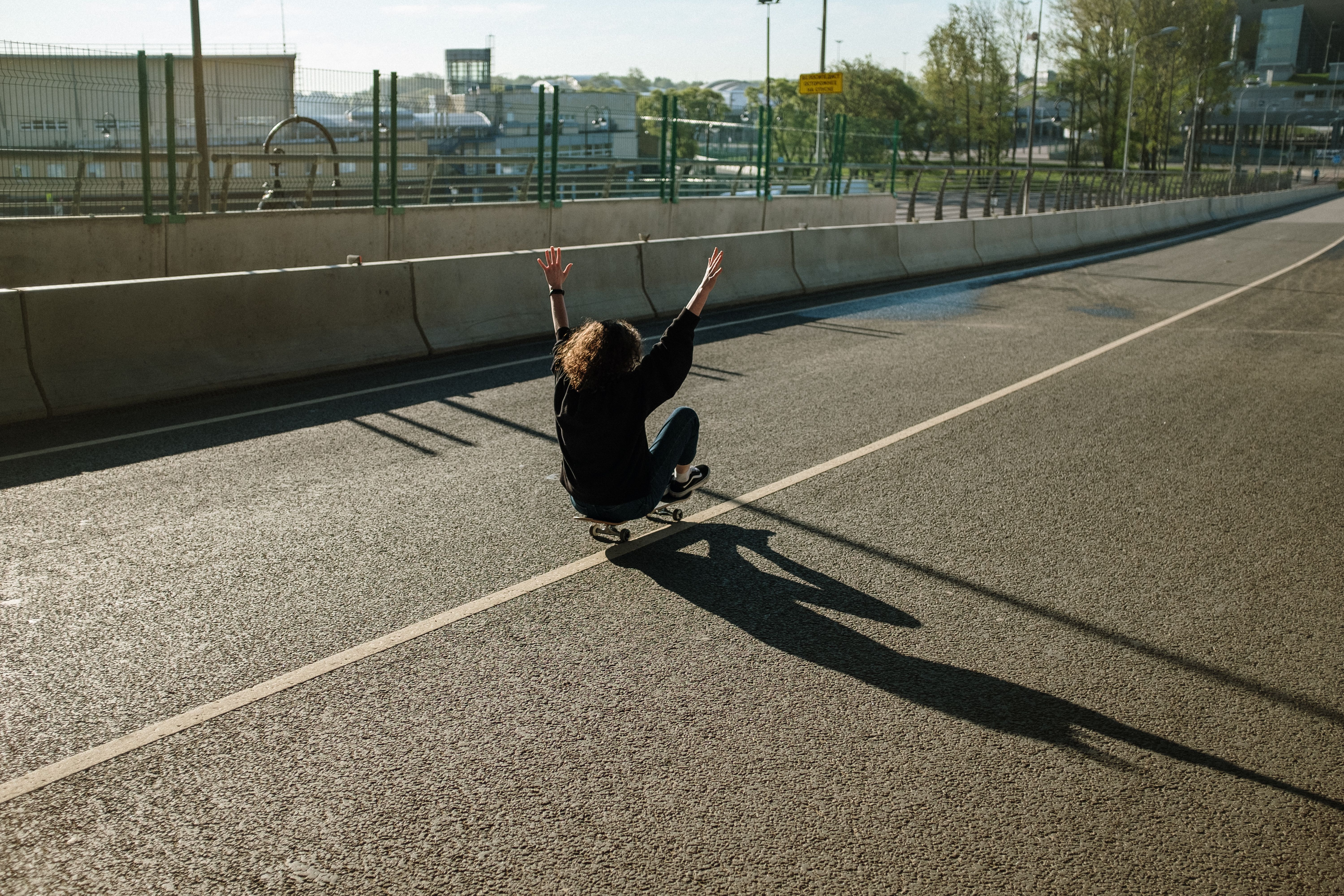 滑板者在空旷的城市道路上滑行，沉浸在自由与运动的喜悦中