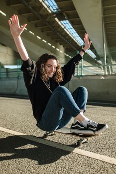 一位快乐的年轻女子在桥下滑滑板，体现了自由和快乐