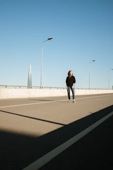 一个女人独自走在空旷的城市公路上，湛蓝的天空下