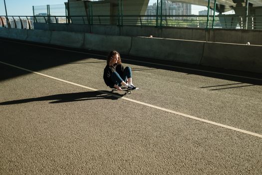 滑板者在空荡荡的城市桥下道路上享受自由的时刻