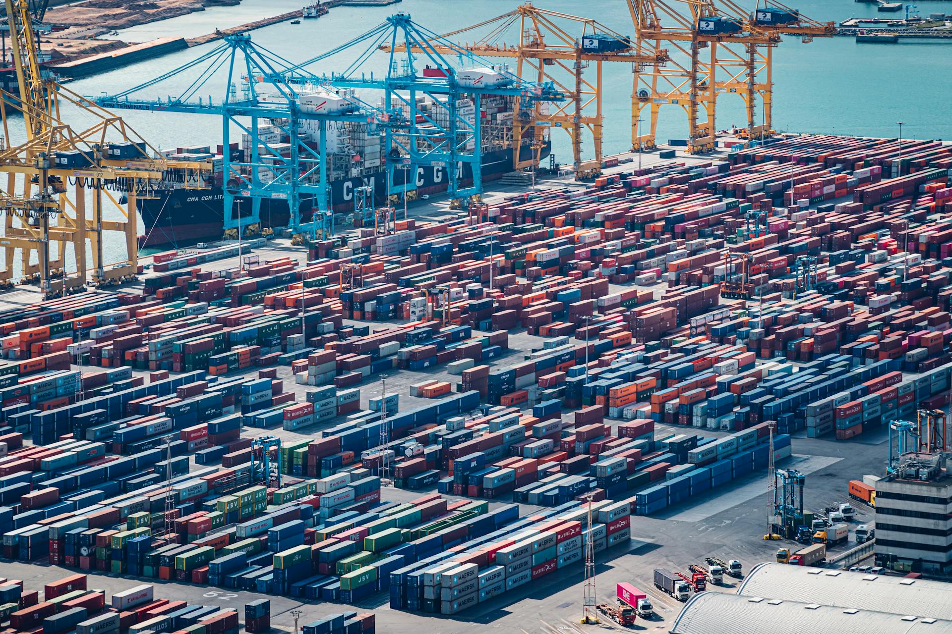 A drone shot of shipping containers at Barcelona Port, Spain, showcasing busy maritime activity.