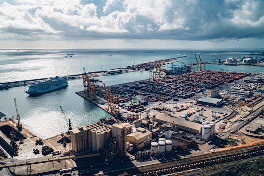 Aerial view of Barcelona port showcasing cargo containers, cranes, and cruise ship.