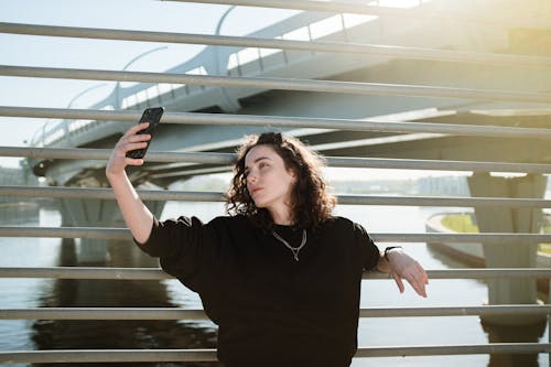 Woman in Black Long Sleeve Shirt Standing and Smiling