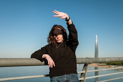 城市桥上，一个人抬起手臂，以城市天际线为背景摆姿势