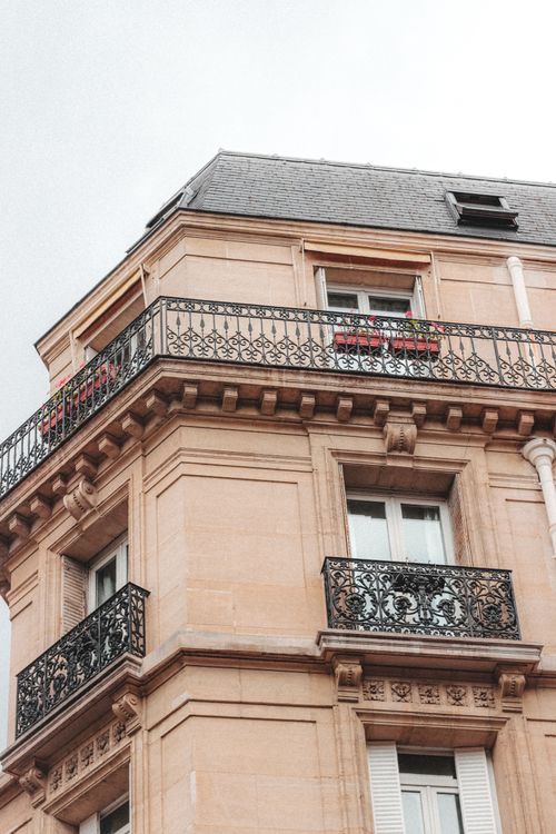 Free Low angle of building with balconies and ornamental columns in residential area of town in cloudy day Stock Photo