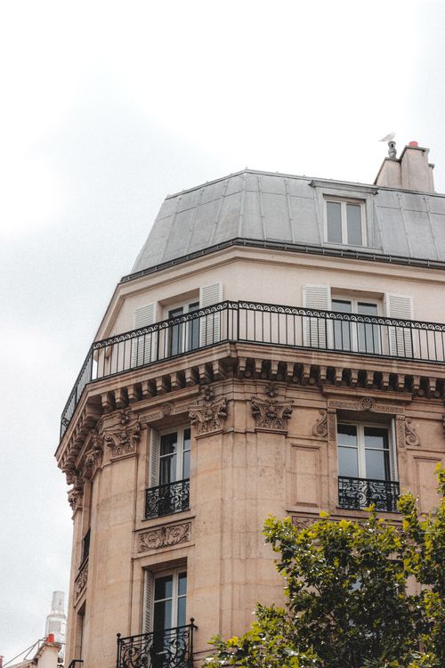 Free From below of corner of historic building with balconies and ornamental facade located in residential district of megalopolis against cloudy sky Stock Photo