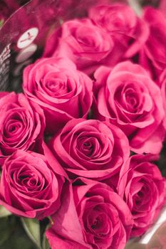 From above of pink roses arranged in bouquet and wrapped in gift wrap