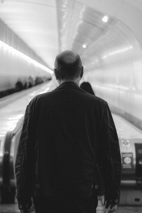 Man walking towards escalator in subway