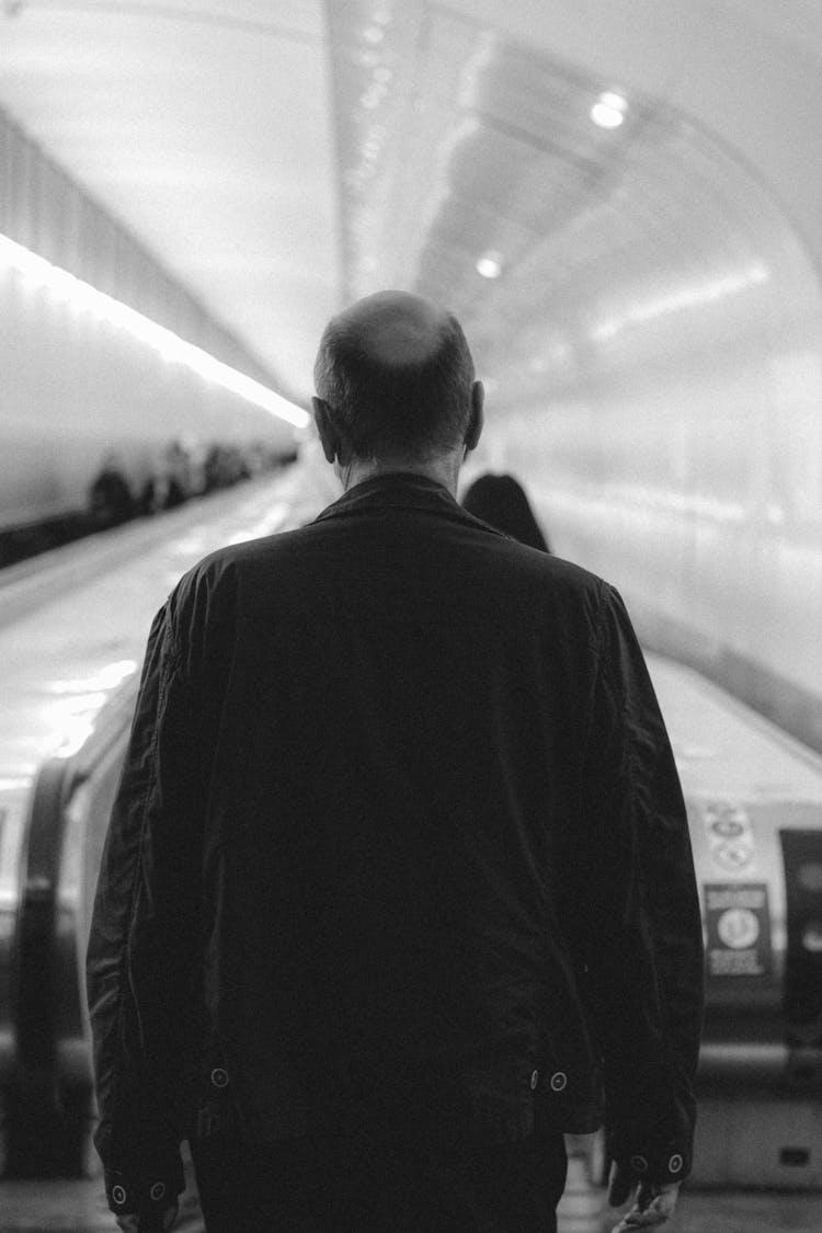 Man Walking Towards Escalator In Subway