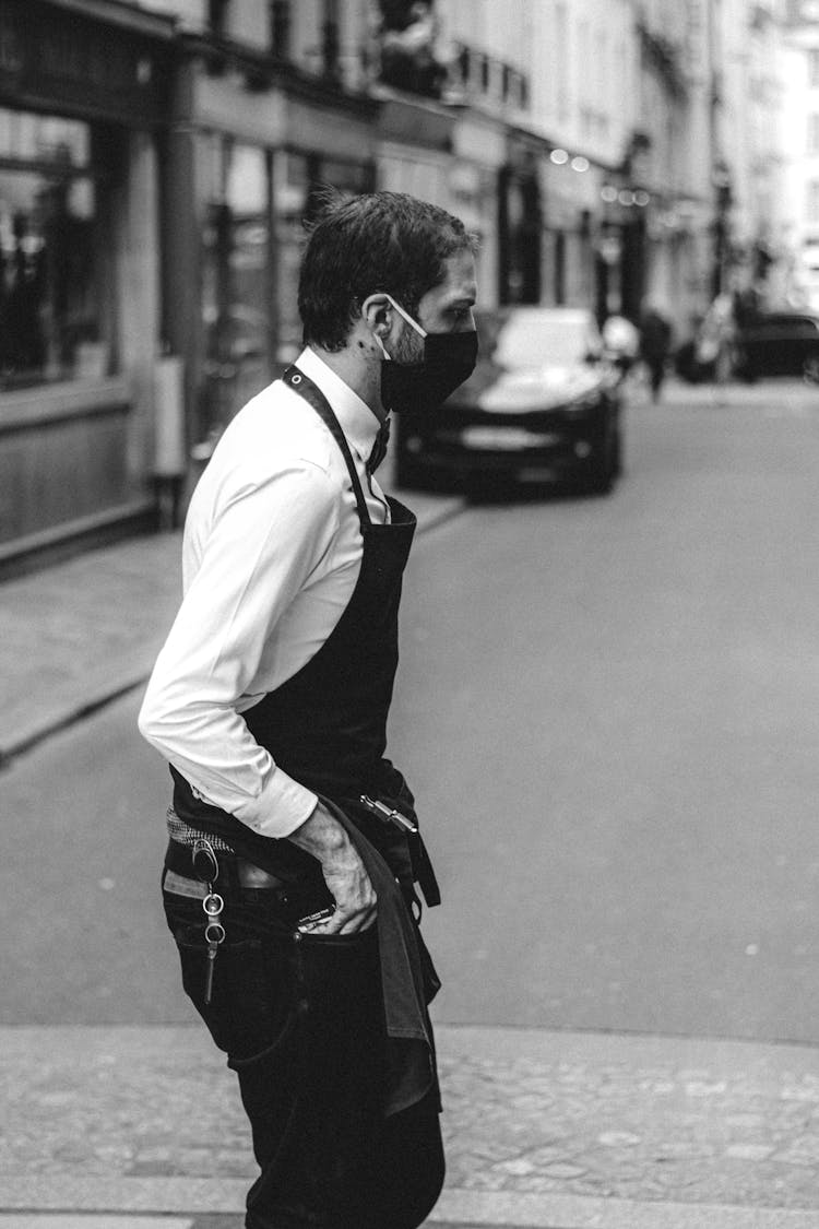 Waiter In Uniform And Mask Crossing Road