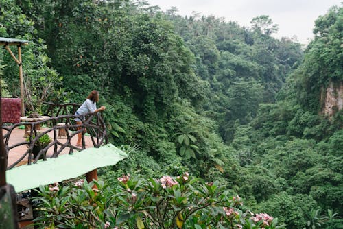 Woman enjoying scenic jungle view from cottage porch