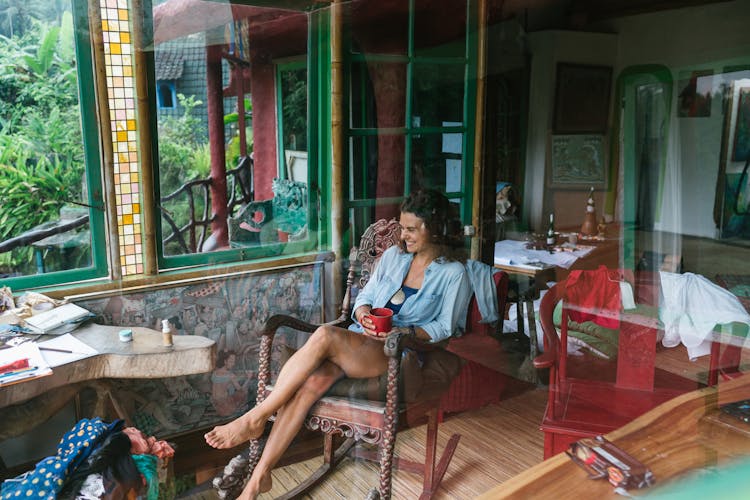 Cheerful Woman On Rocking Chair In Rural House