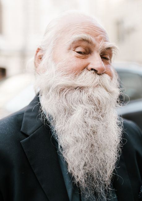Happy senior man with white haired beard and mustache smiling and looking at camera