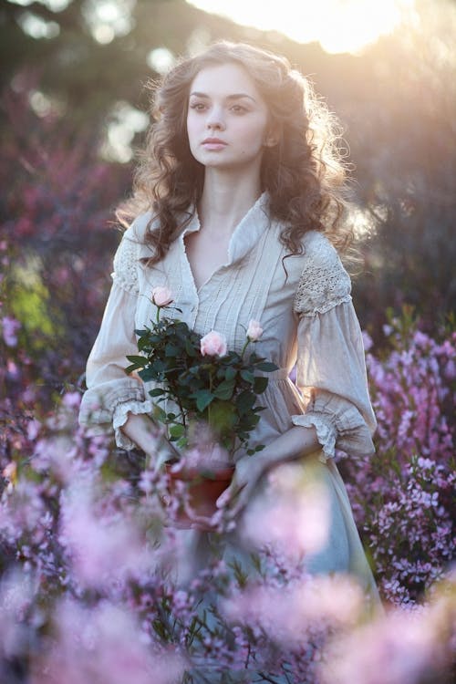 Free Portrait of Beautiful Woman Holding Flowers Stock Photo