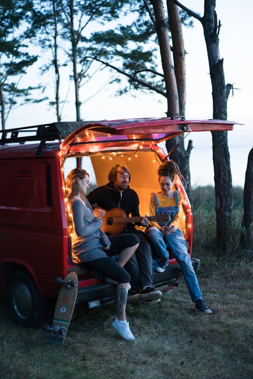 Free A Group of Friends Sitting at the Back of the Camper Van Stock Photo