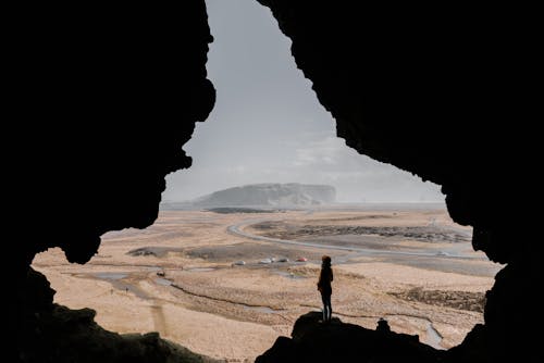 Free Person on Cave Entrance Looking At Sea View Stock Photo