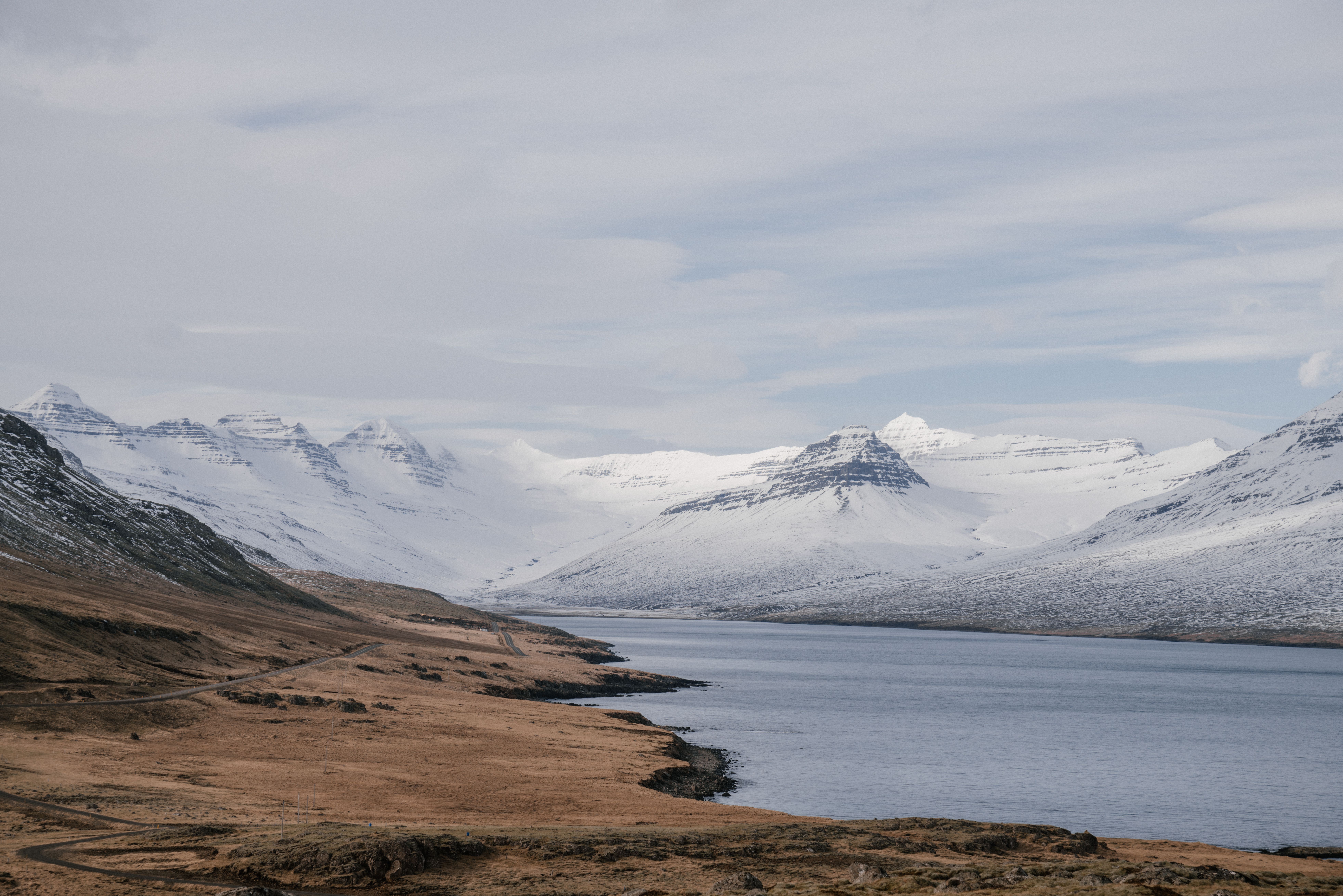 A breathtaking view of a snow-capped mountain range with a serene lake. Perfect for nature and travel enthusiasts.