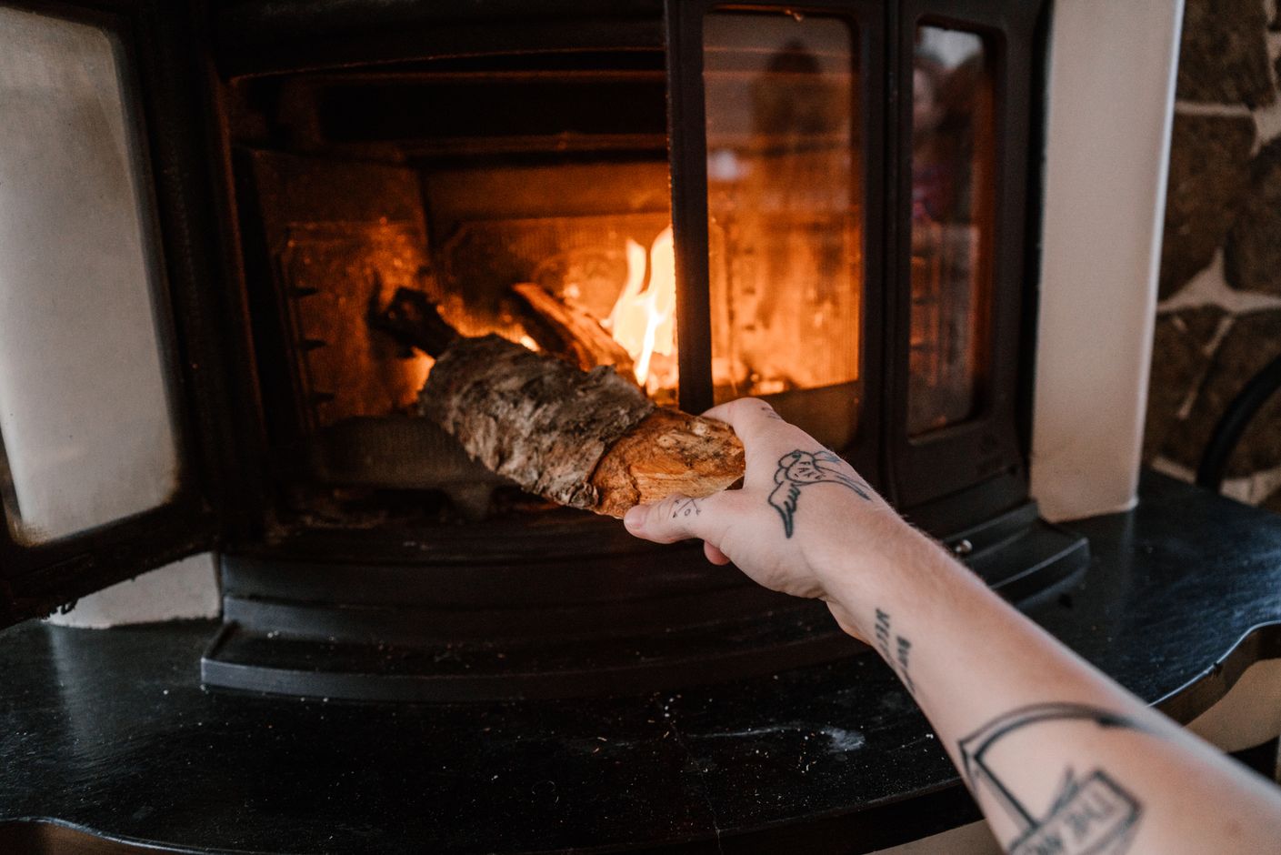 Seasoned firewood being placed into a hearth