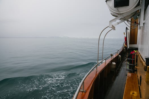 A tranquil boat journey through a calm, misty sea, capturing serenity and isolation.