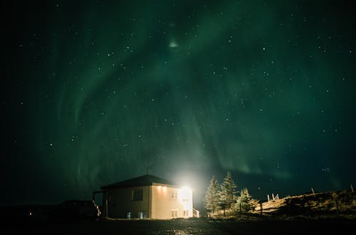 Free  Illuminated House with Northern Lights on the Sky Stock Photo