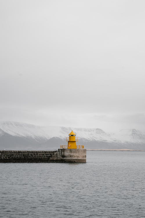 Lighthouse on Pier near Mountains