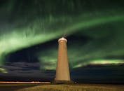 夜空中，一座灯塔在充满活力的北极光下闪耀