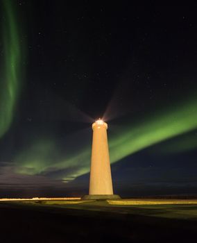 在北极光和繁星点点的夜空构成的戏剧性背景下，一座令人惊叹的灯塔照亮了四周