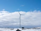 Wind Turbines on Snow Covered Ground Under Blue and White Sunny Cloudy Sky