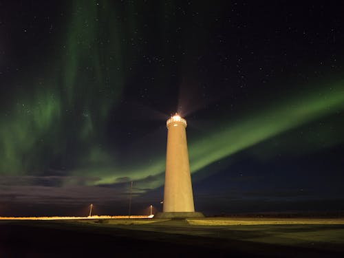 Free Photo of a Lighthouse against Night Sky with Northern Lights Stock Photo