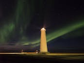 夜空中，灯塔的光芒与令人惊叹的北极光交相辉映