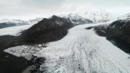 Glaciers Flowing through Winter Mountains