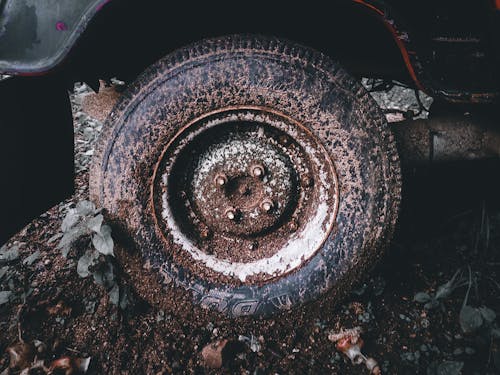 Broken stacked in dirt wheel of auto
