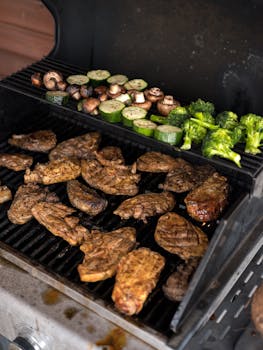 Juicy steaks and fresh vegetables sizzling on a barbecue grill, perfect for a summer cookout.