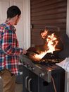 Man in Red and White Plaid Dress Shirt Cooking Meat