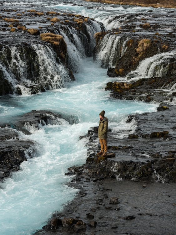 Man Standing on Rocks by Stream · Free Stock Photo