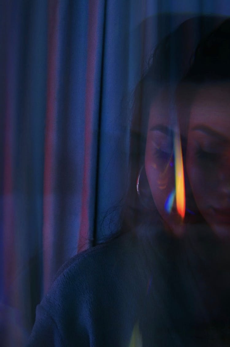 Blurred Shot Of A Woman Near Dark Curtains