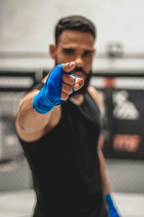 Determined young ethnic fighter pointing at camera