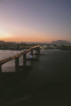 日落时分，无人机拍摄下风景如画的沿海城市，现代河上桥梁在天空下熠熠生辉
