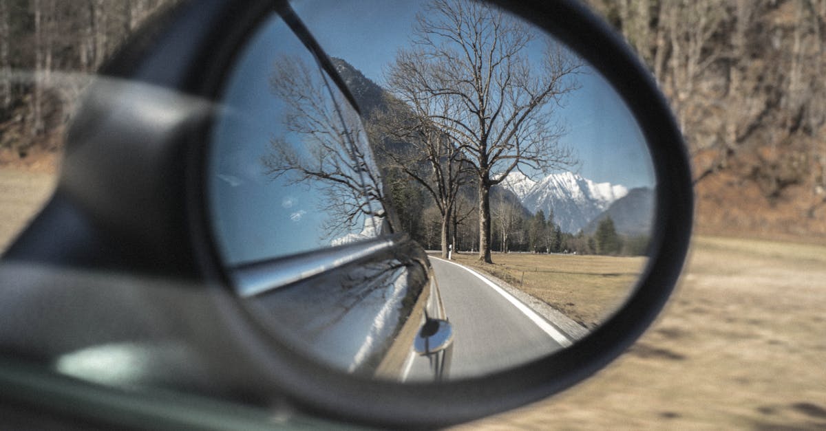 Person Showing Photo of Road on Wing Mirror