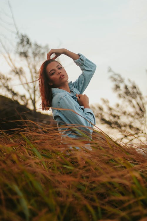 Stylish young woman resting in field in countryside