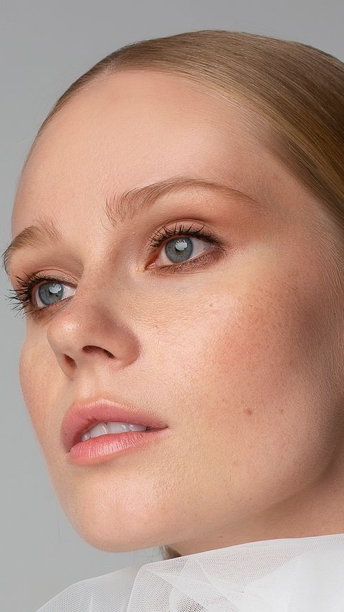 Free Close-up portrait of a blonde woman with blue eyes gazing thoughtfully, showcasing beauty and elegance. Stock Photo
